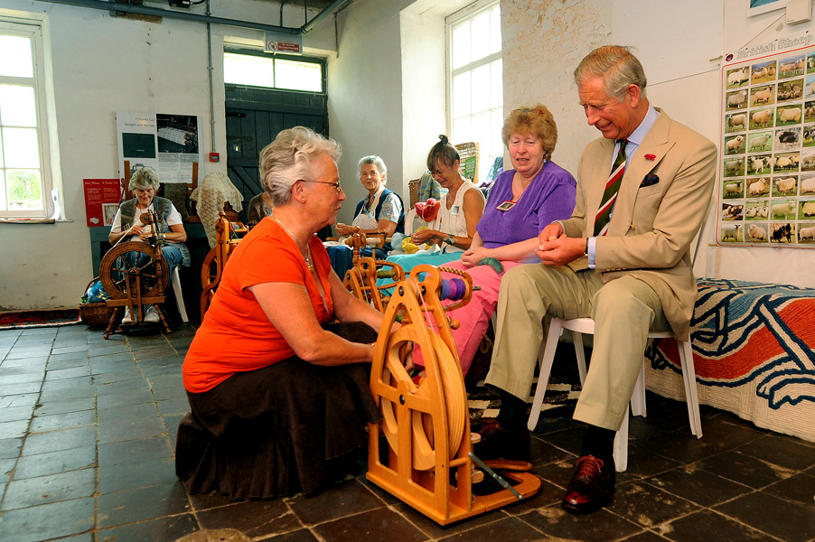  HRH Prince Charles is taught how to spin wool by Sandy Prescott on a visit to the National Wool Museum in West Wales, 2010
